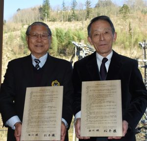 トカイナカヴィレッジ松本氏と西川村長が協定書を持ち並んで写っている写真