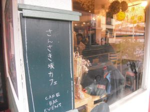 さんさき坂カフェと書かれた看板が店舗外壁に掲示されている写真