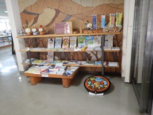 棚に沢山のパンフレットやのぼり旗のレプリカなどが展示されている場所にポケふたが展示されている様子を写した写真