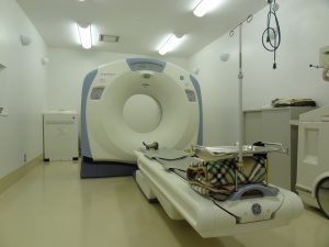 四角形の形をした機械の中央部分に丸い穴が開いており、ベットが置かれているCT装置の写真