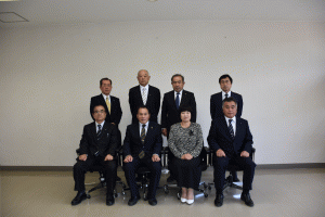 8名の議会関係者の方々が前列は椅子に座り、後列は立って2列に並び写っている記念写真